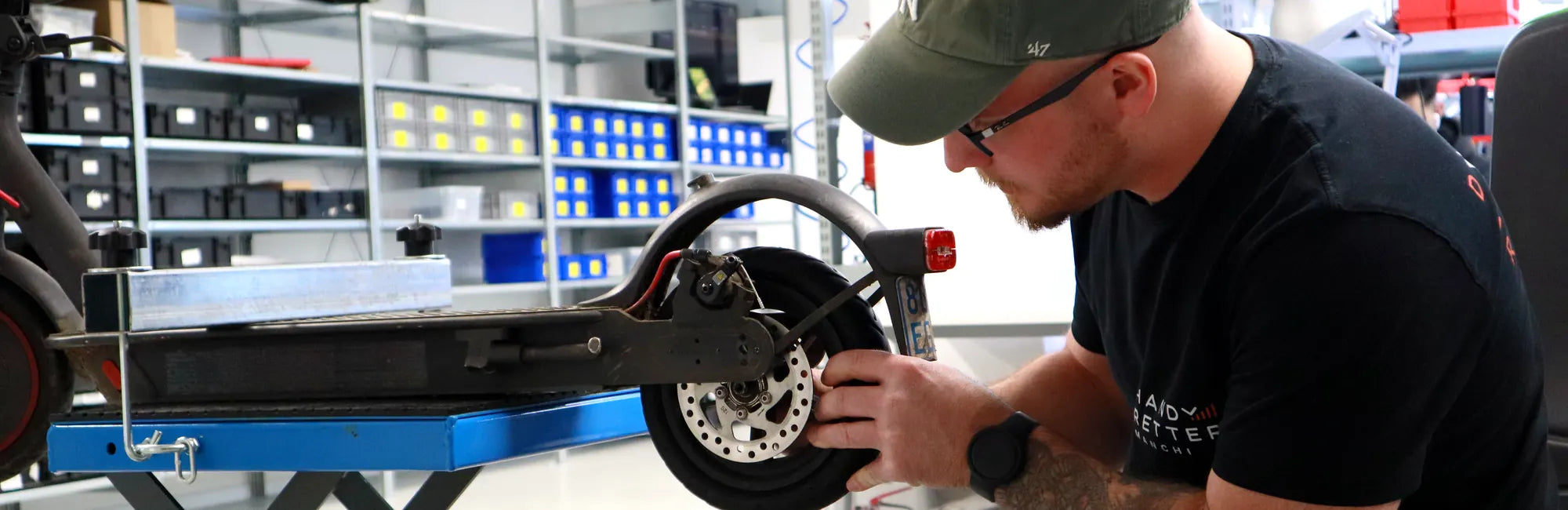 E-Scooter Reparatur in der Werkstatt — HandyRetter Techniker repariert Bremsscheibe und Hinterrad